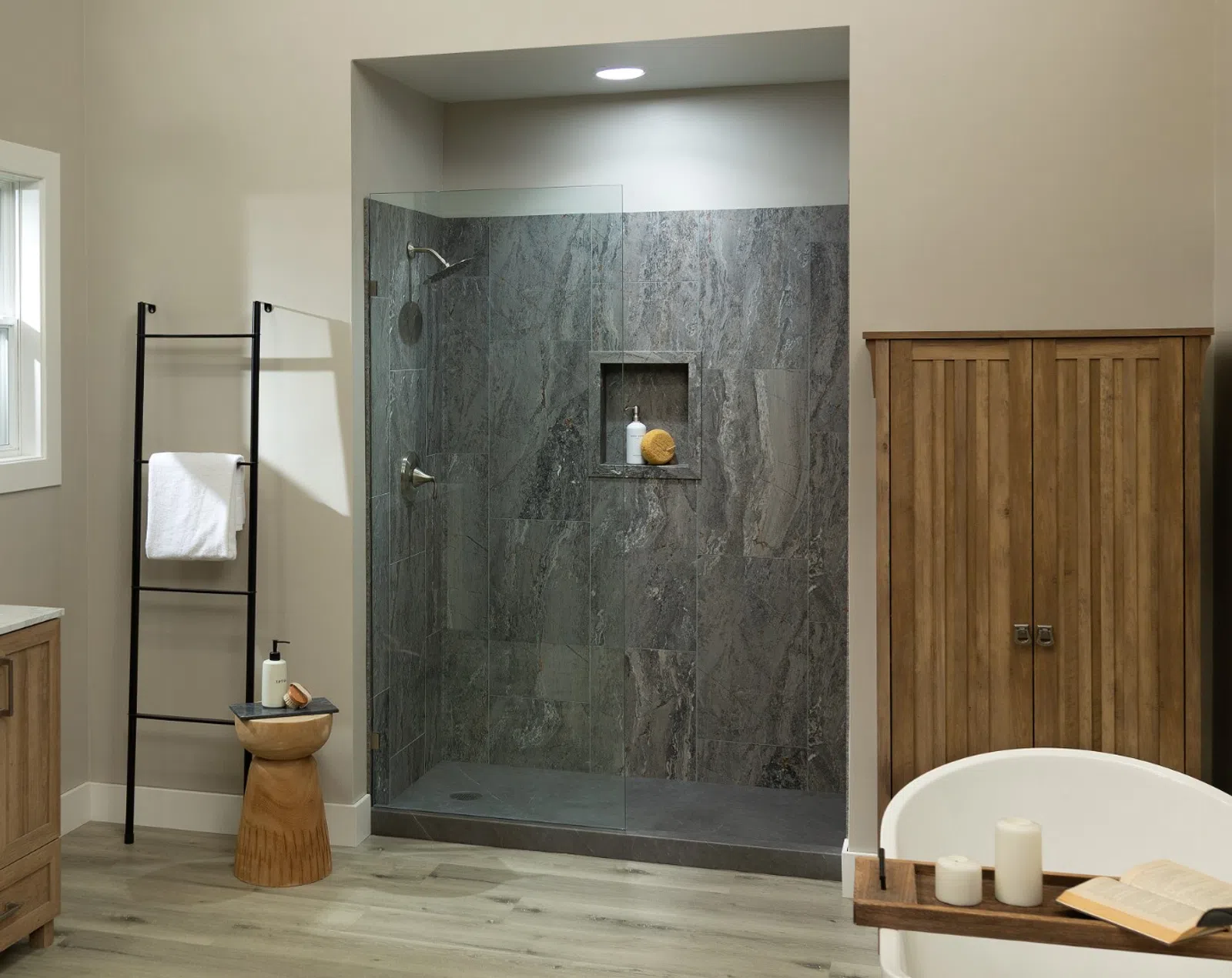 Modern bathroom with wooden vanity, glass shower, freestanding tub, and neutral color scheme
