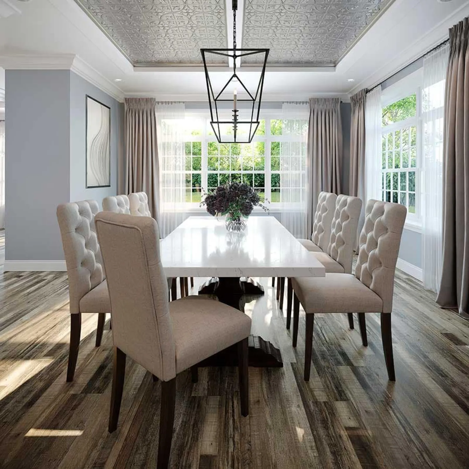Bright dining room with a white table, beige tufted chairs, wooden floors, and large windows with curtains.