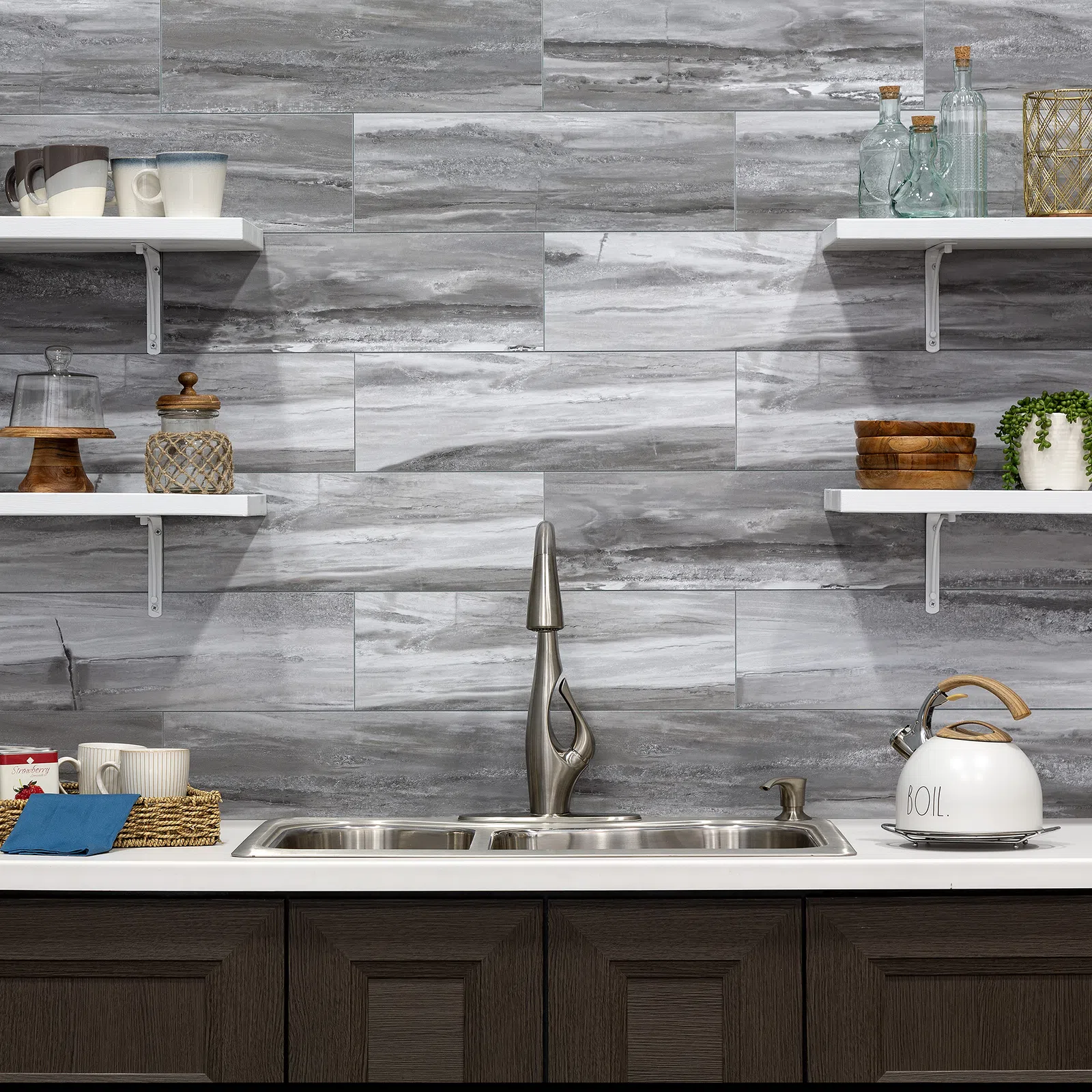 Modern kitchen with stainless steel sink, stylish faucet, gray marble backsplash, and open white shelves.