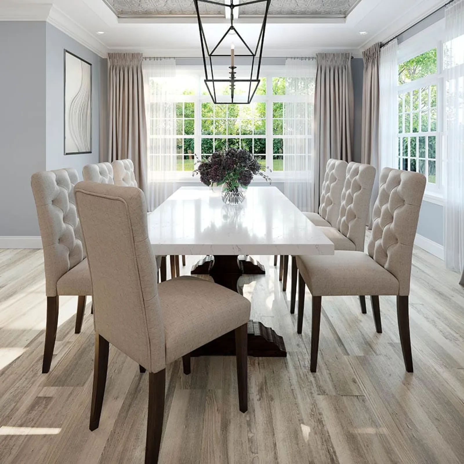 Modern dining room with beige tufted chairs, white marble table, large windows, and natural wood flooring.