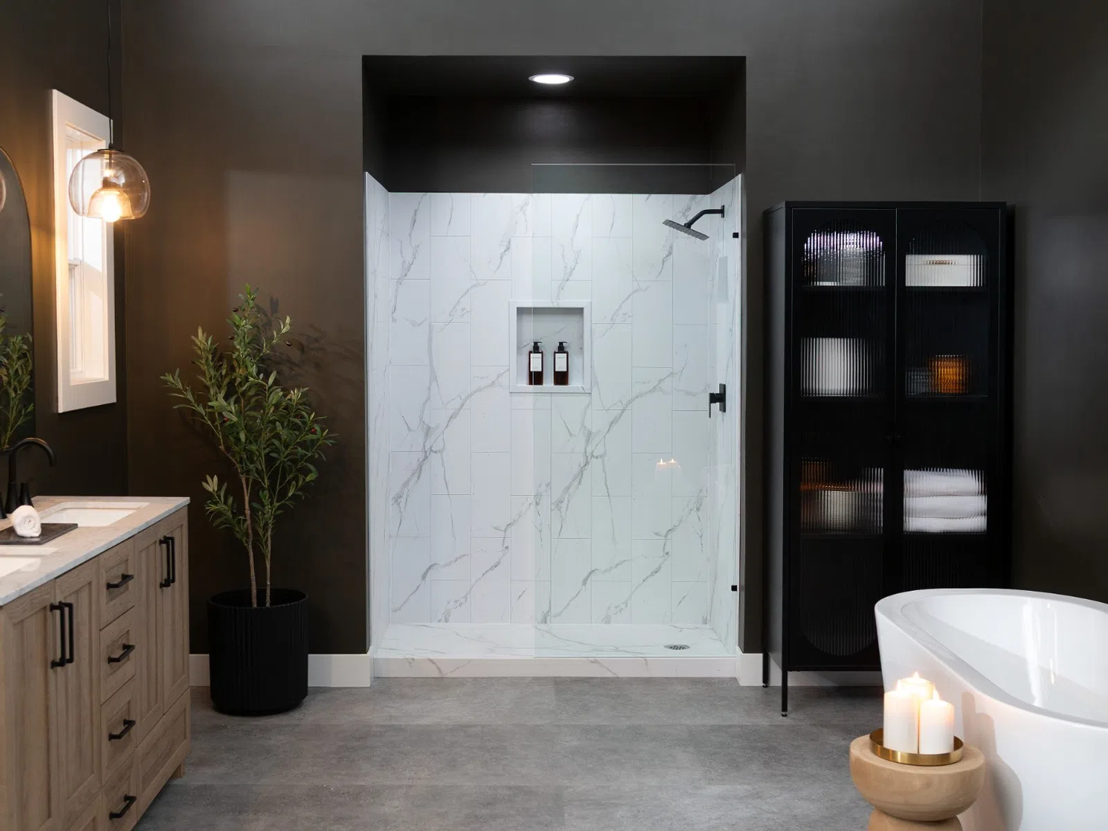 Modern bathroom with freestanding tub, wooden vanity, glass shower, black cabinet, and decorative lighting.