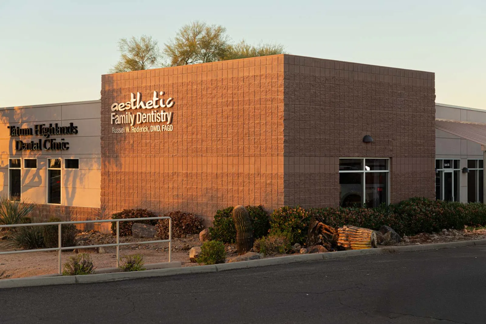 Exterior view of a dental clinic building with signage for Aesthetic Family Dentistry and Tatum Highlands Dental Clinic.