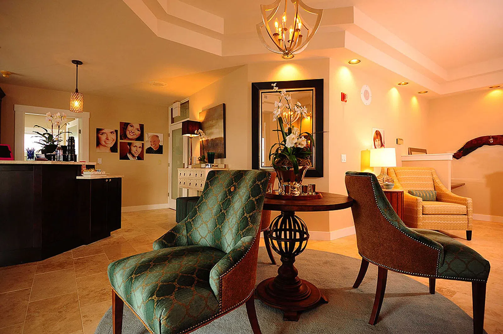Cozy waiting area with green upholstered chairs, wooden table, soft lighting, and warm beige walls in a modern interior.