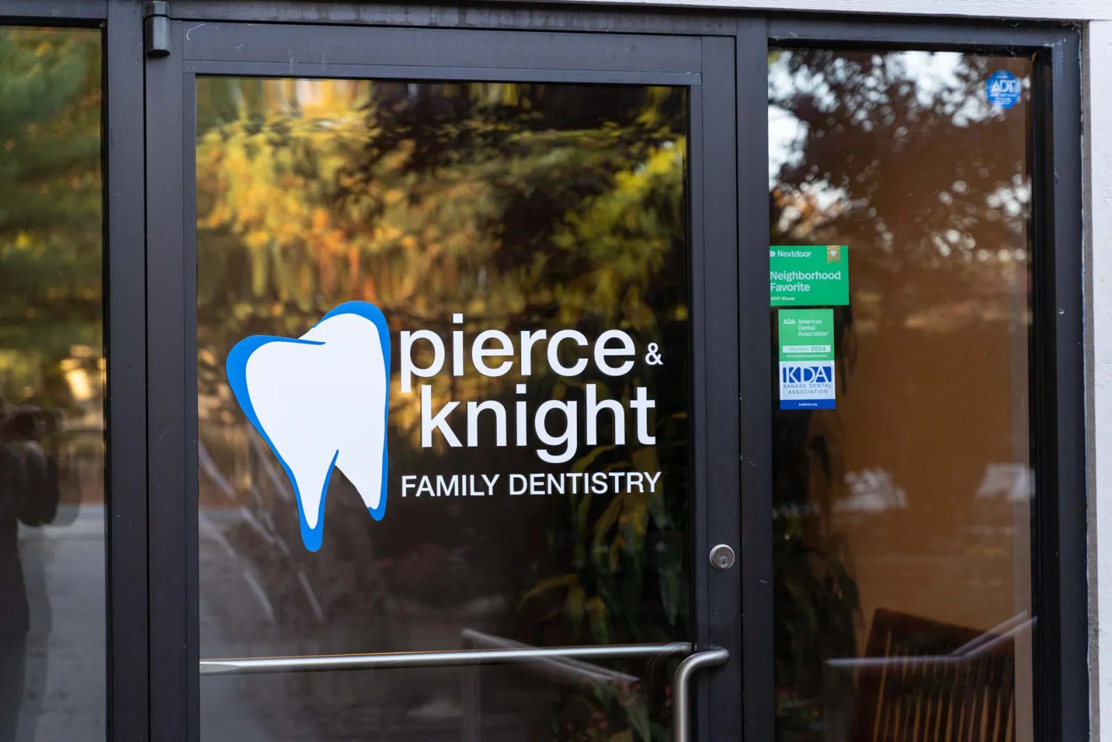 Pierce & Knight Family Dentistry logo with a blue and white tooth icon on a glass door.