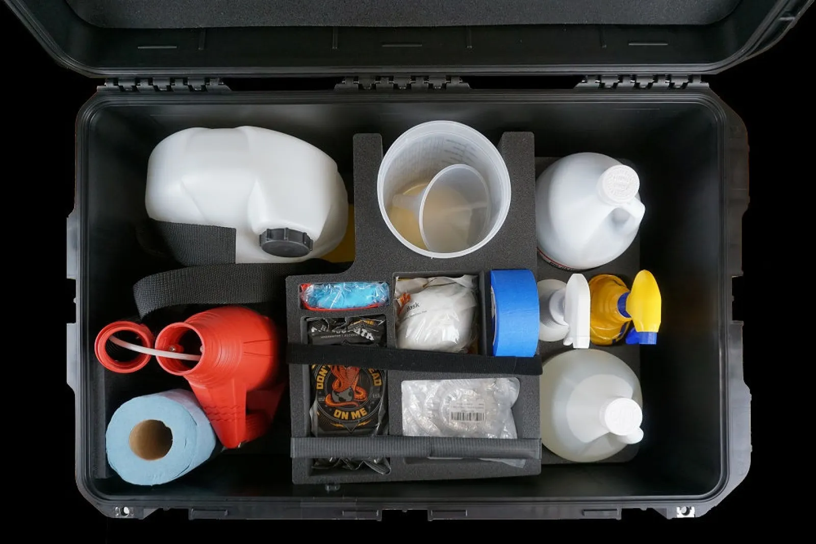 Top view of organized black toolbox containing cleaning and maintenance supplies including bottles, gloves, and tape.