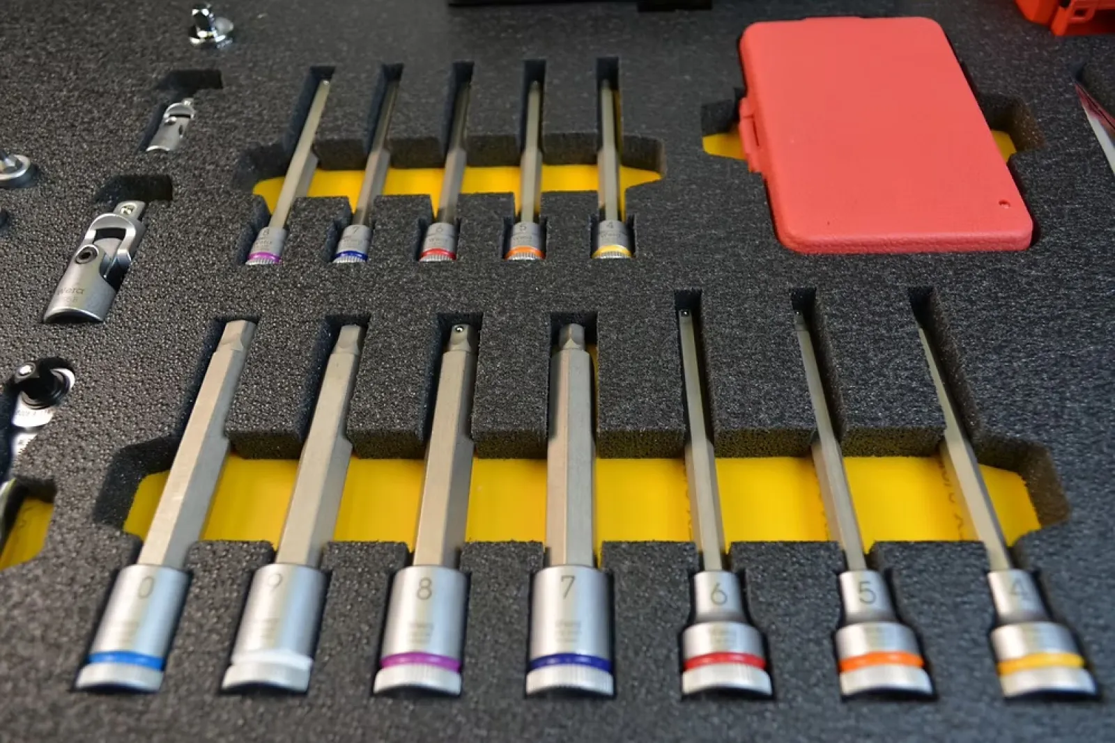 Set of precision hex and torx screwdriver bits neatly organized in foam with a red plastic case.