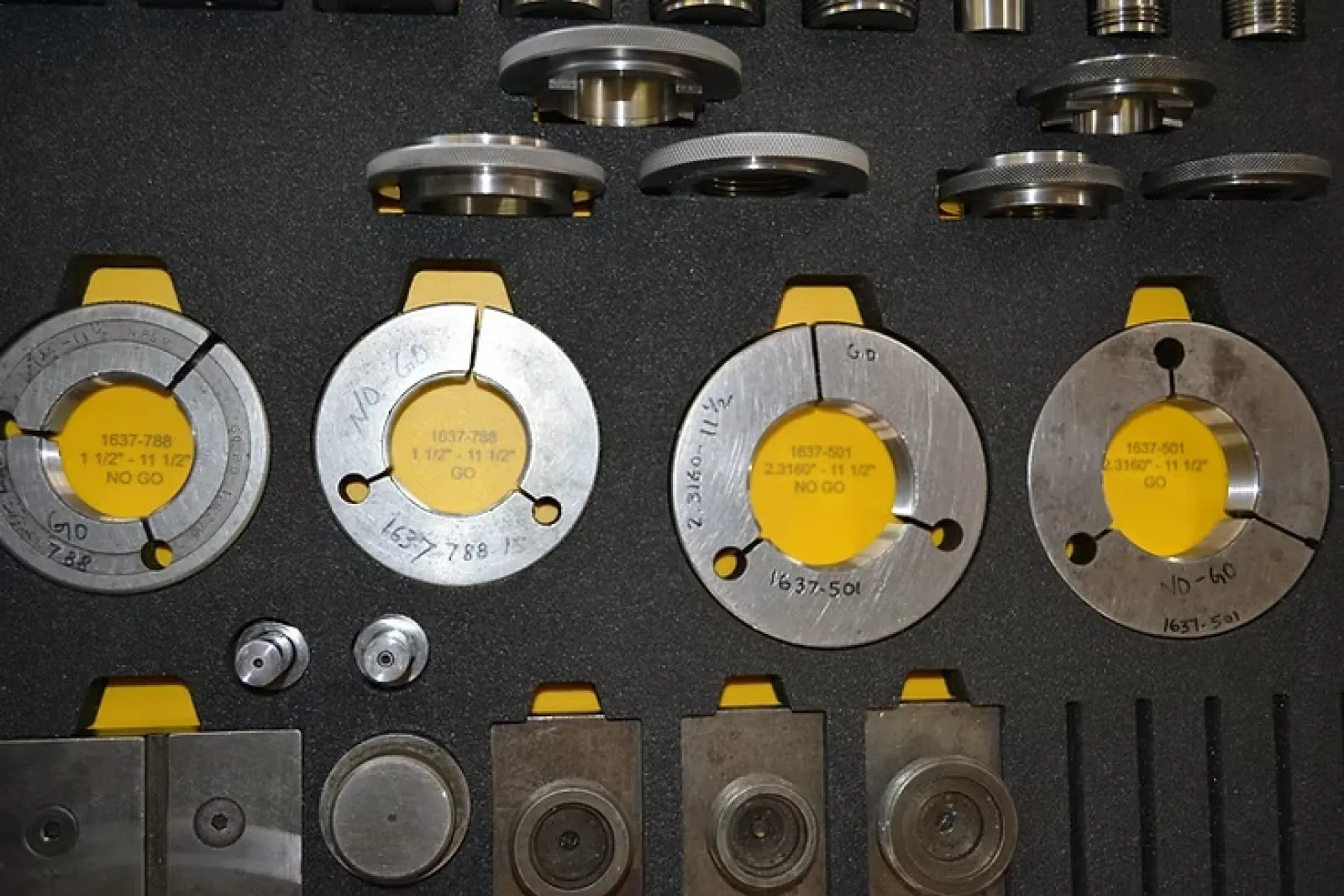 Set of precision metal gauge rings and measuring tools neatly arranged in a tool case.
