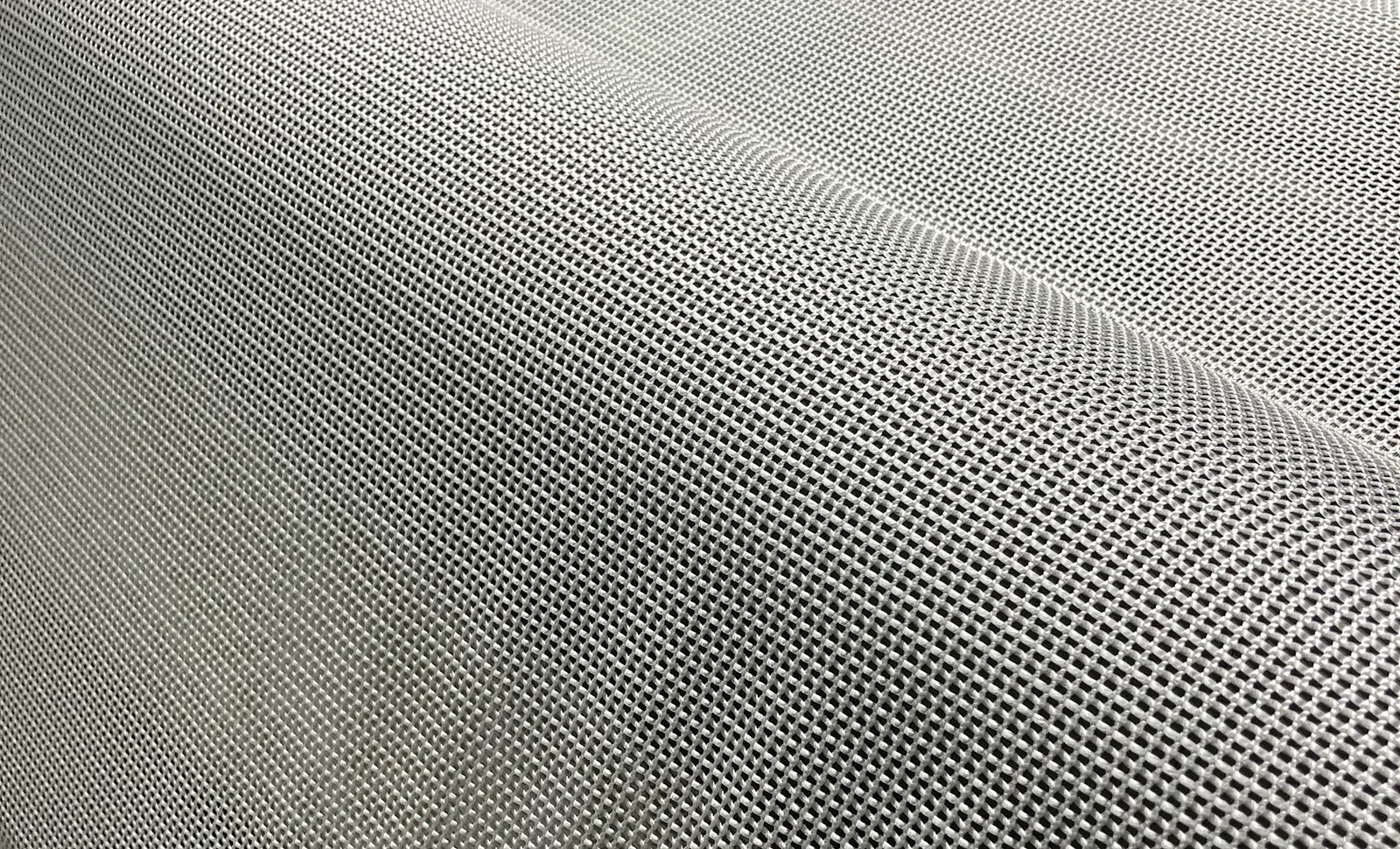 Close-up of a fine metal mesh fabric showcasing a woven grid pattern with a silver-gray finish.