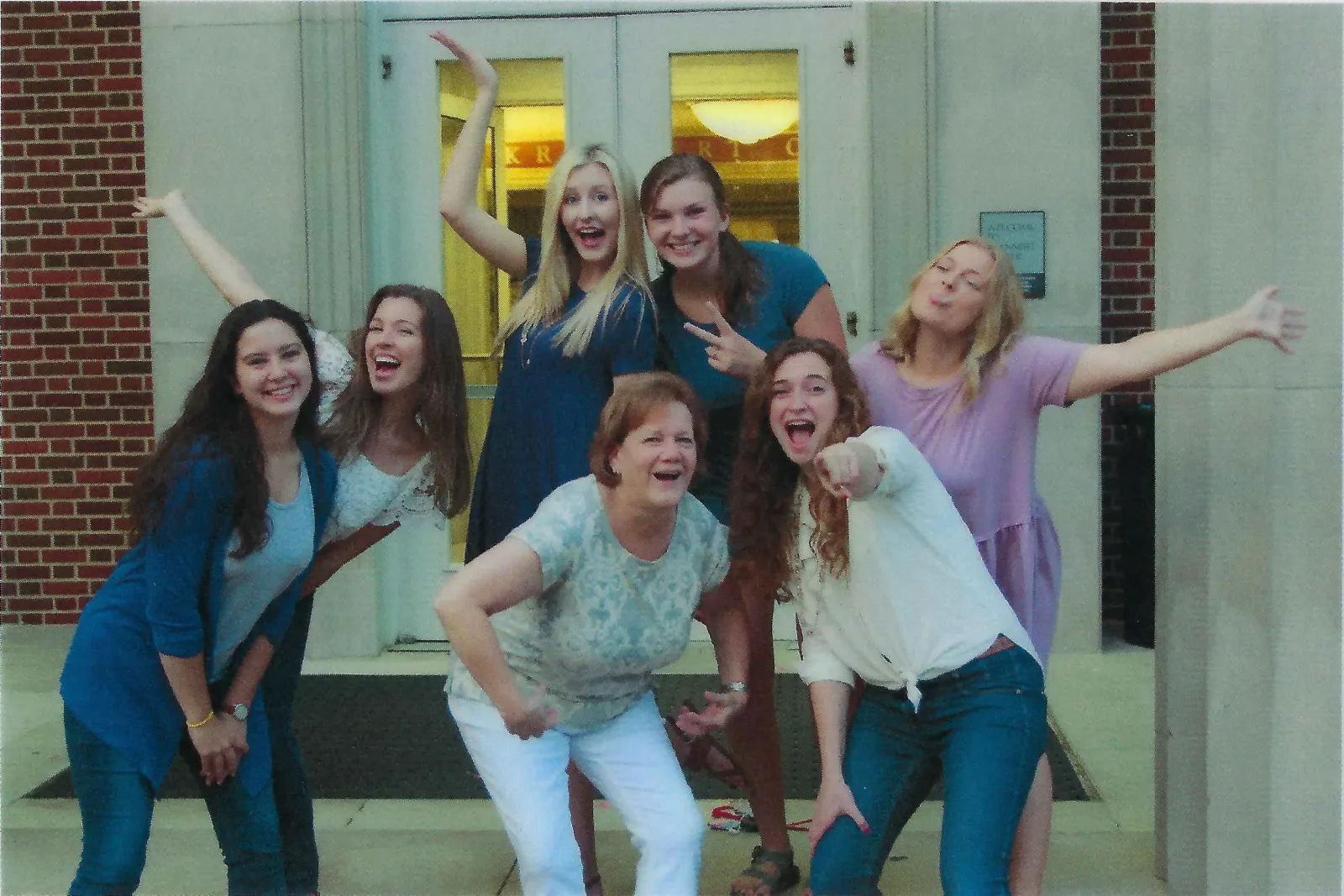 Sue Tarpley and students strike a silly pose on stairs.