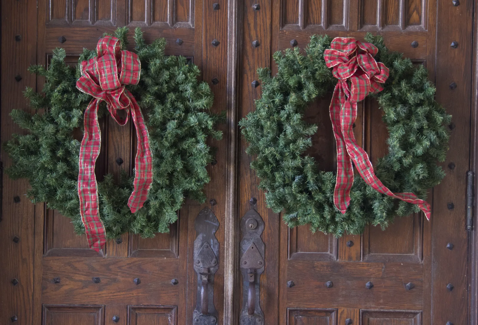 a group of red and green scarfs on a wooden door