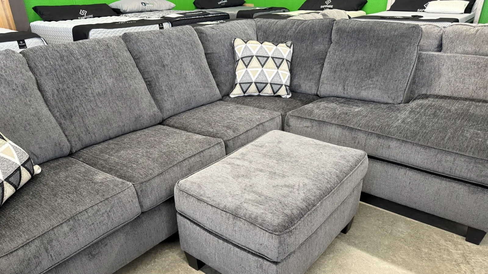 a grey couch with white and black pillows