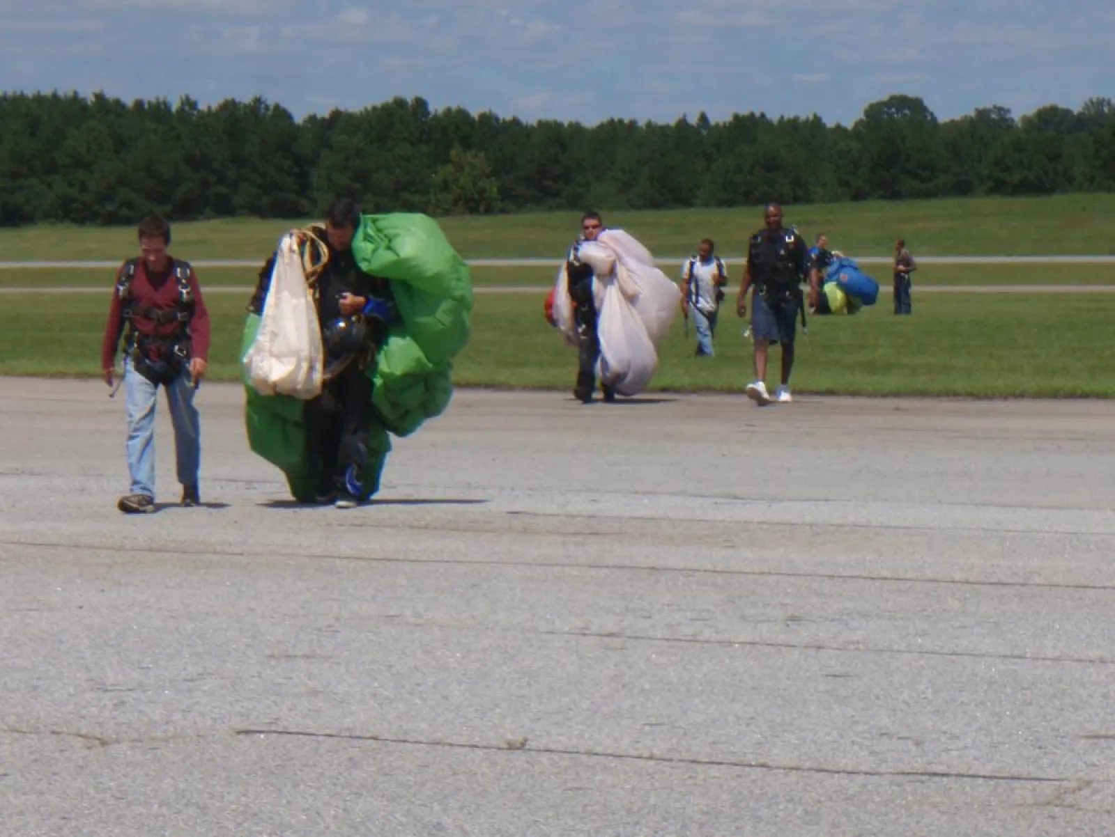 a group of people walking back from sky diving