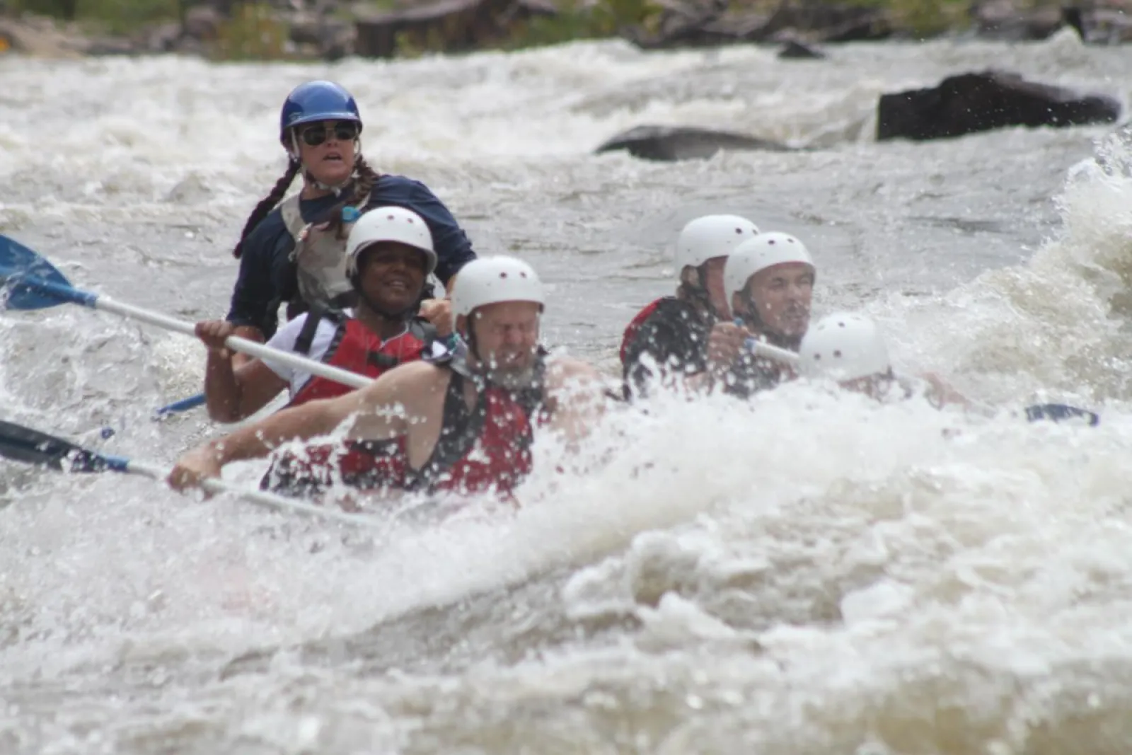 a group of people getting splashed on a raft