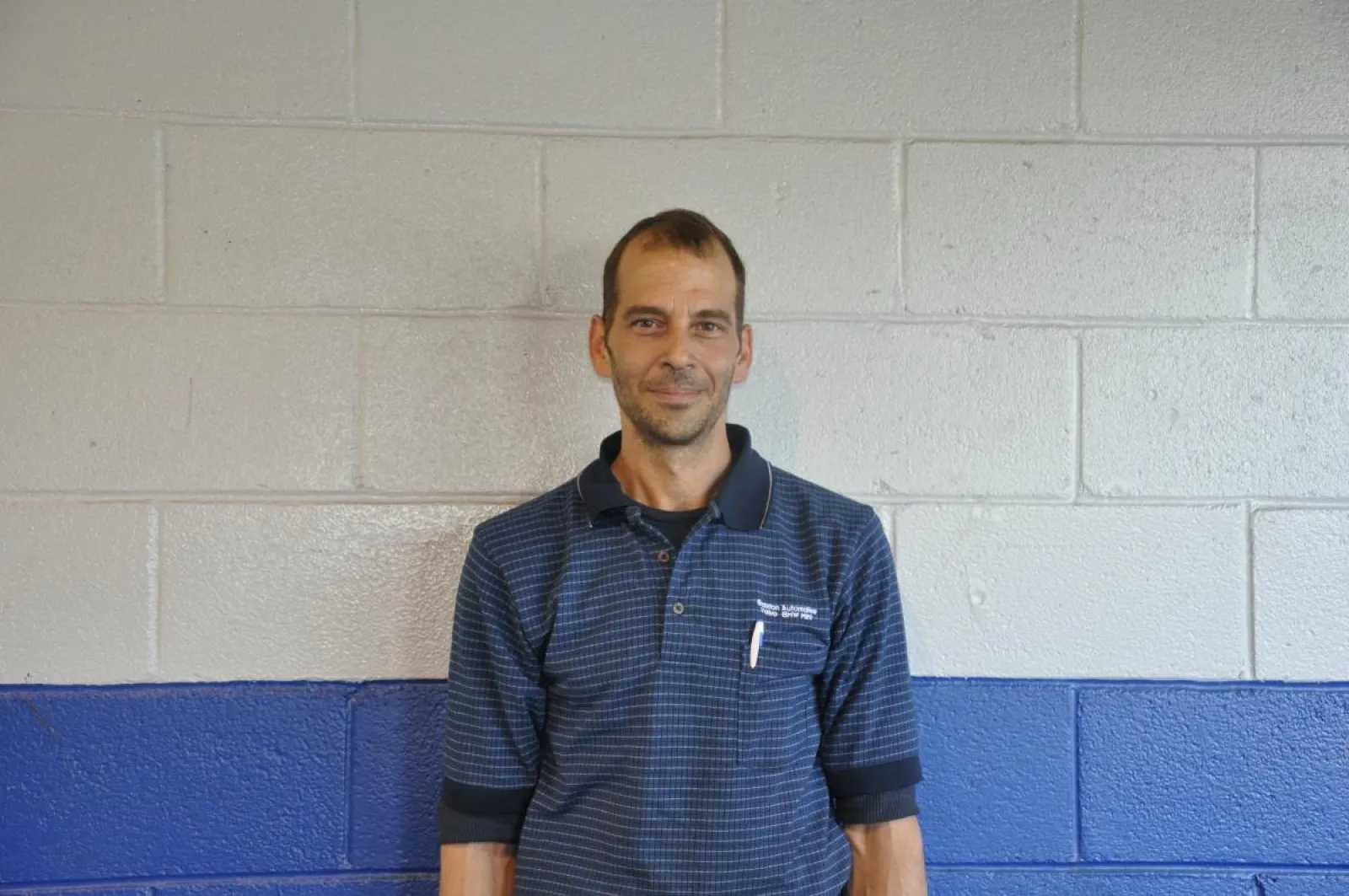 a man standing in front of a blue and white wall