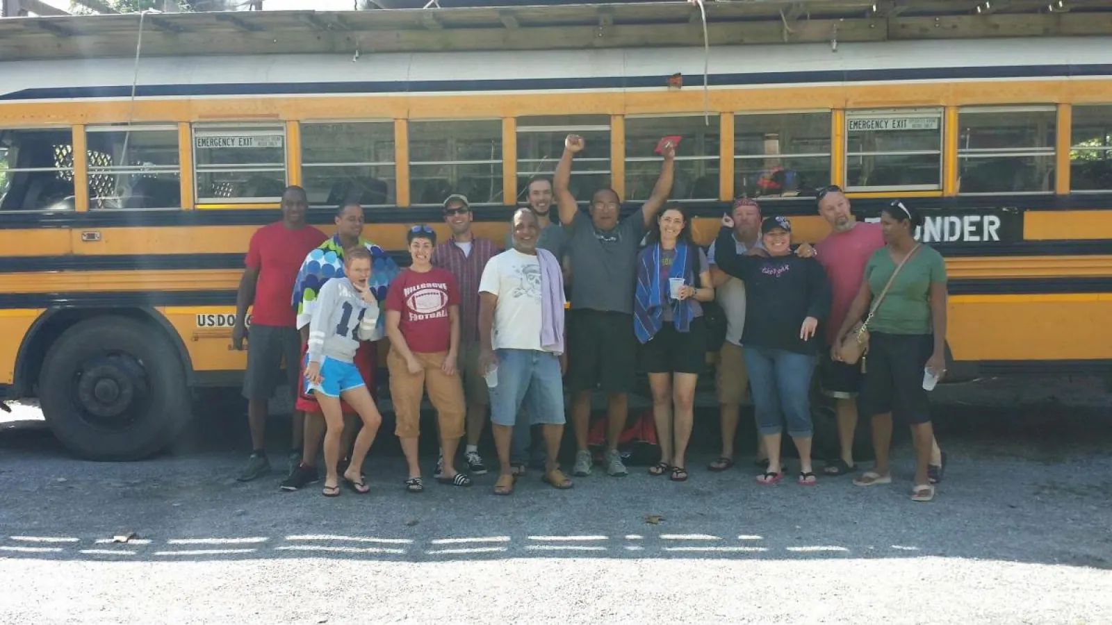a group of people standing in front of a school bus