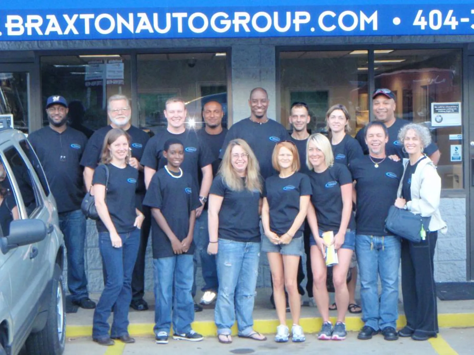 a group of people posing for a photo in front of a building