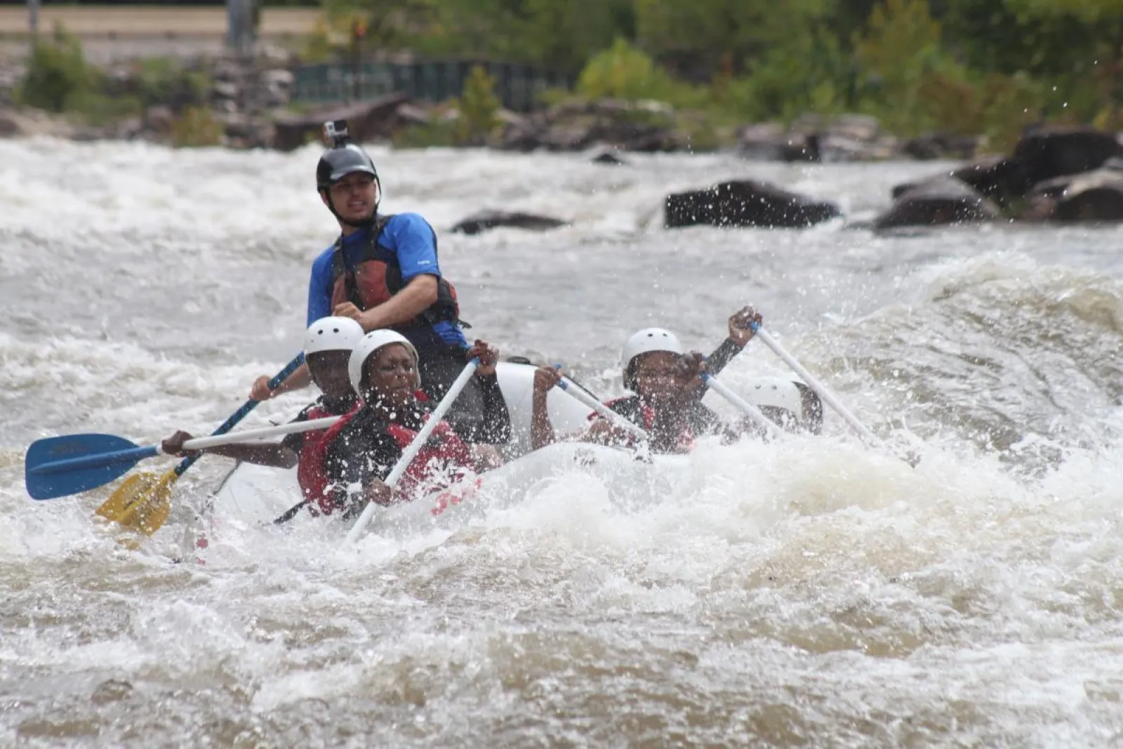 people riding in a raft on the rapids