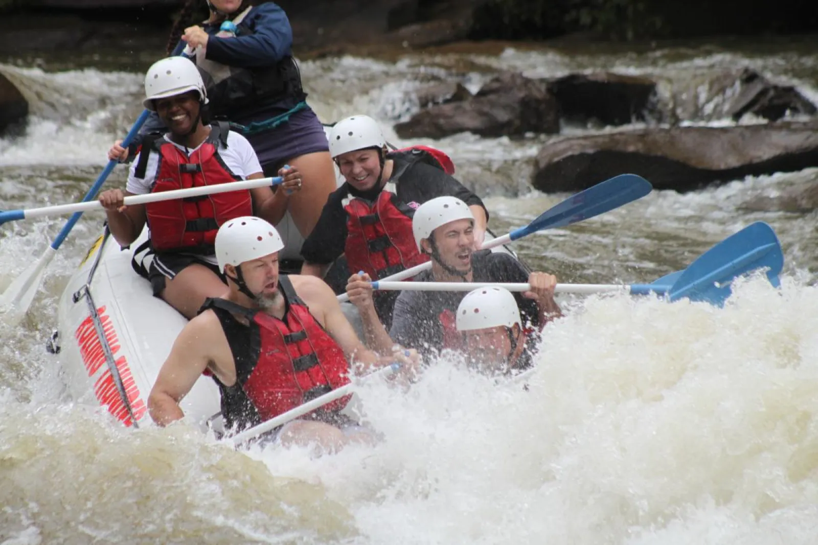 a group of people riding through rough waves