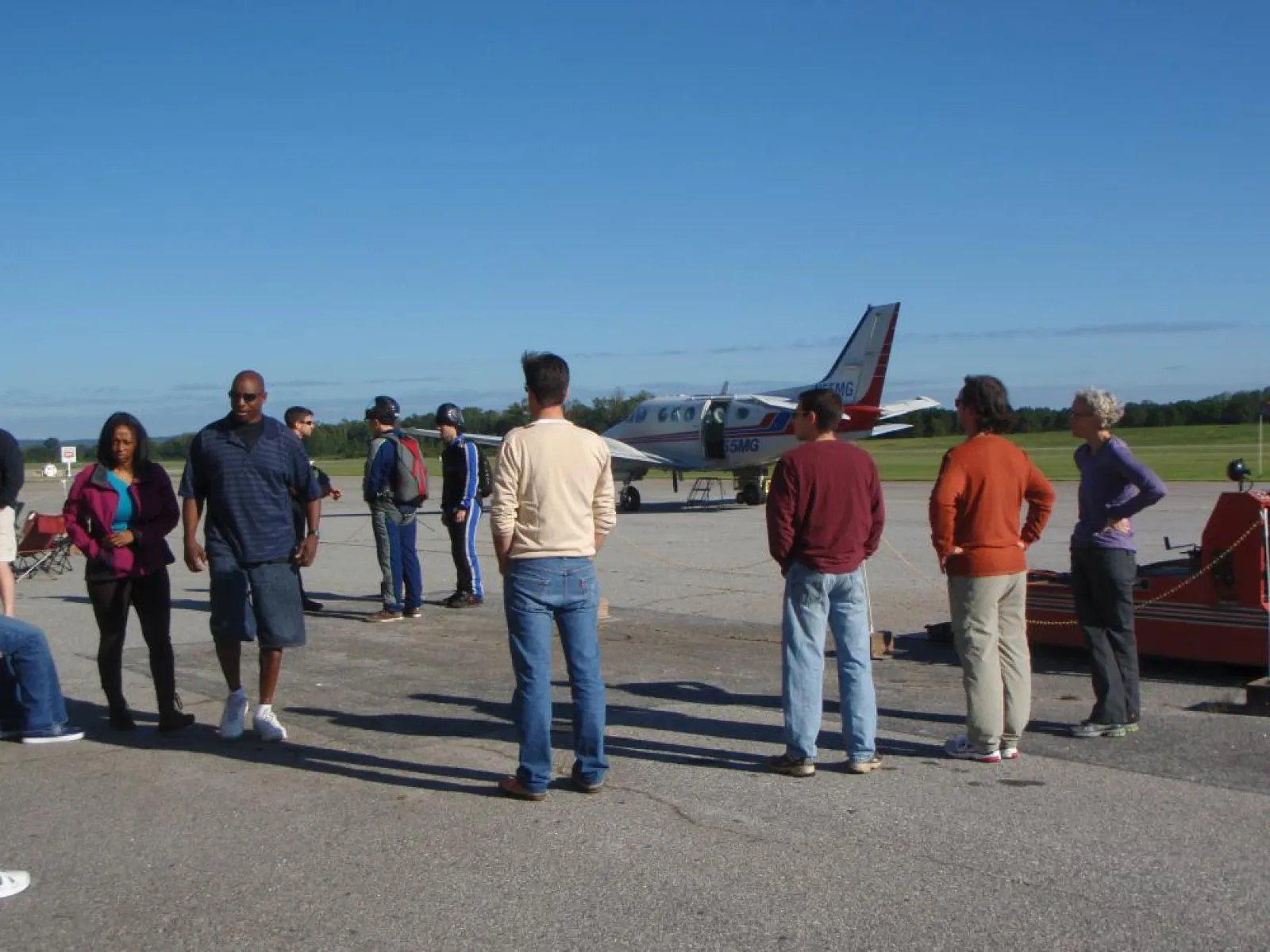 a group of people standing around a plane