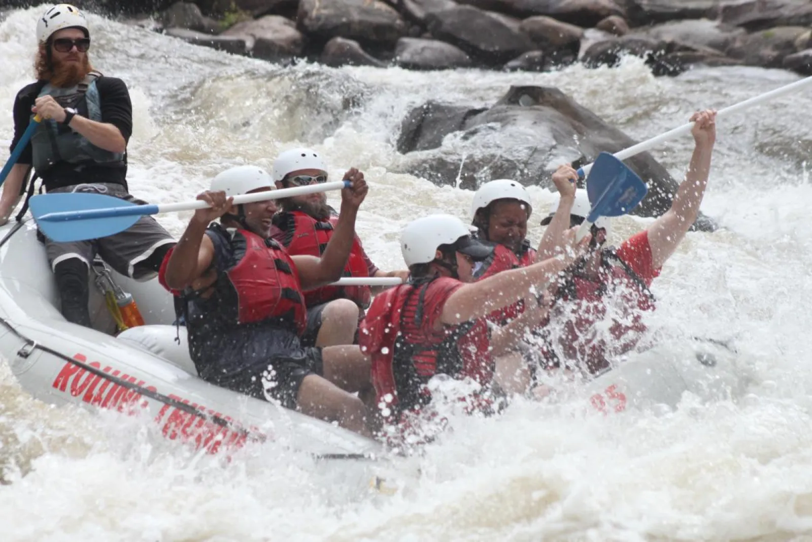 a group of people riding on the rapids in a raft