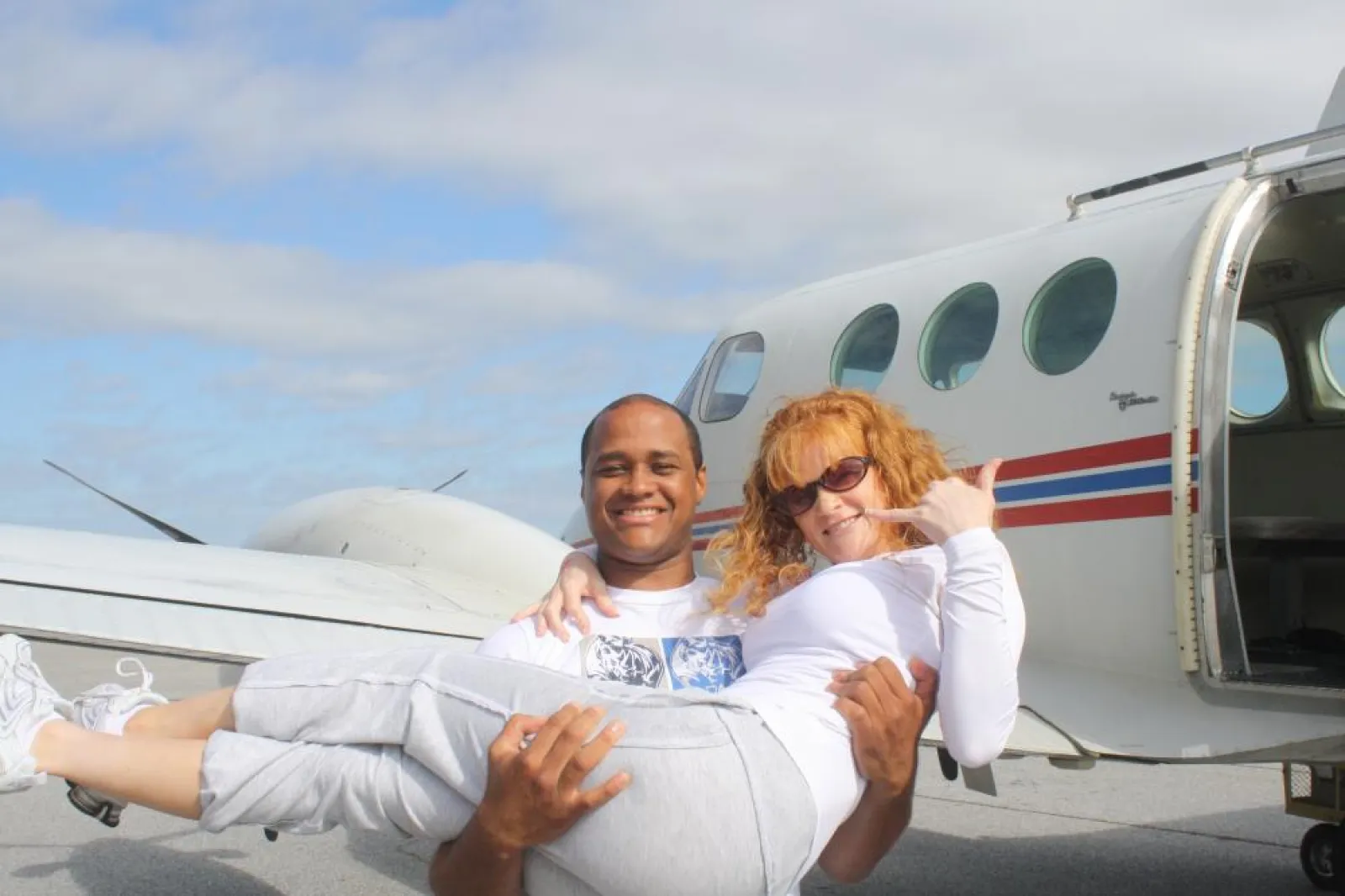 Two people in front of a plane