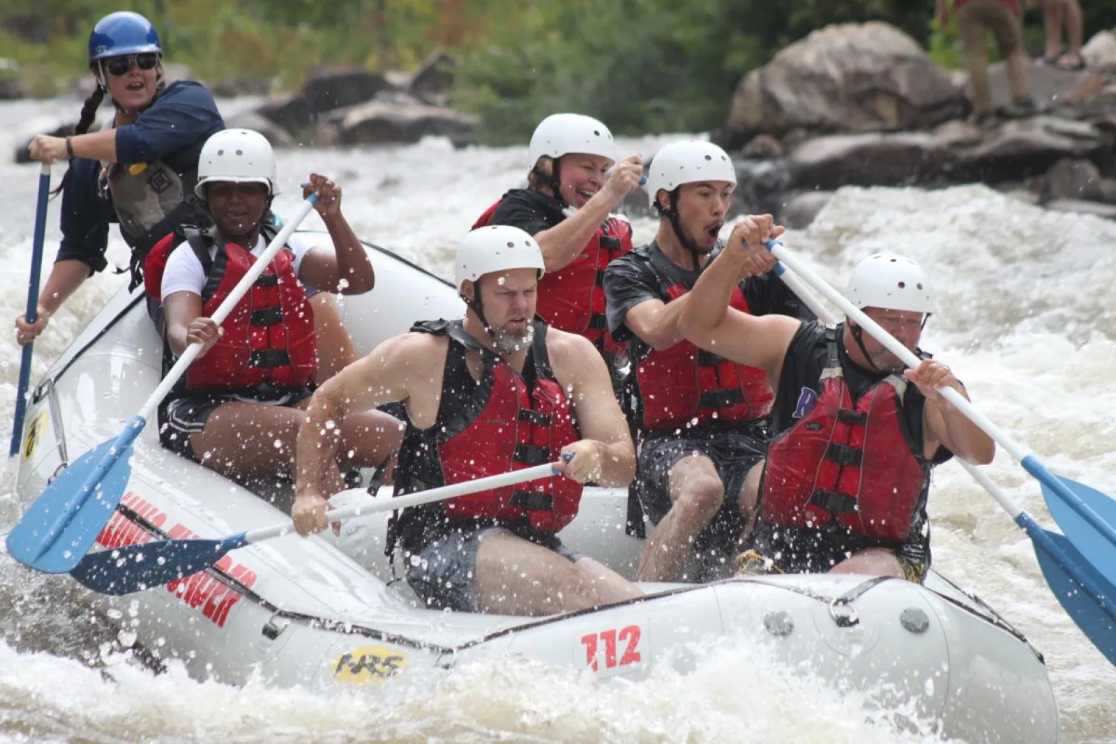 a group of people on a raft in rapids