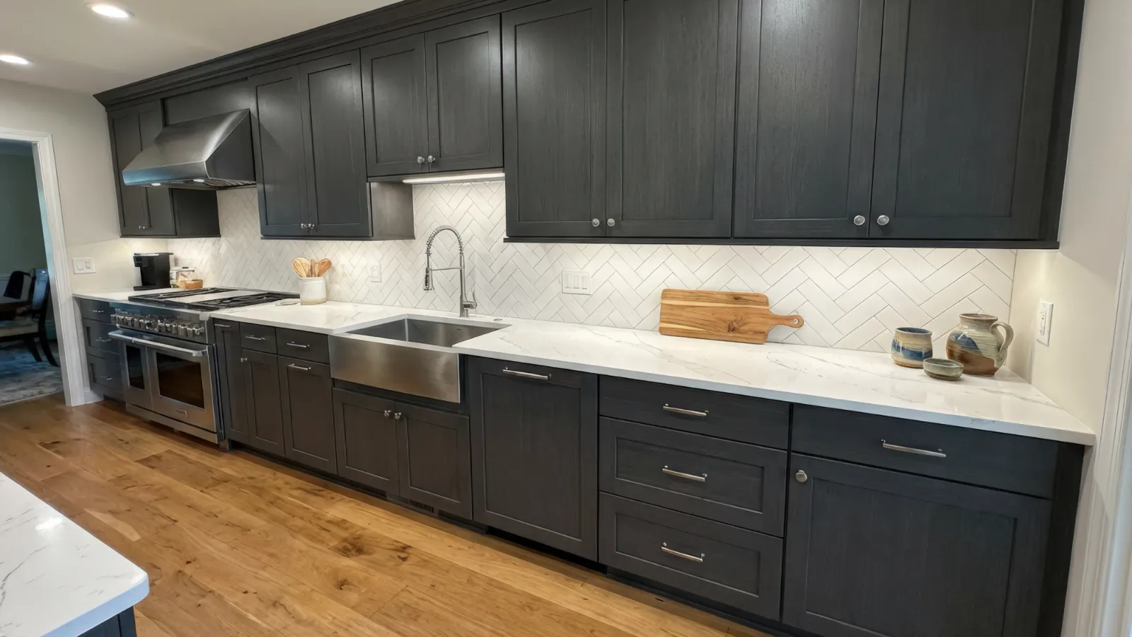 Modern kitchen with dark wood cabinets, white marble countertops, farmhouse sink, and stainless steel appliances.