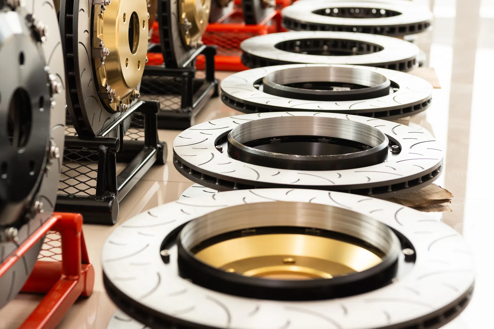 Close-up of several metallic brake discs arranged in a row with detailed grooves and polished surfaces.