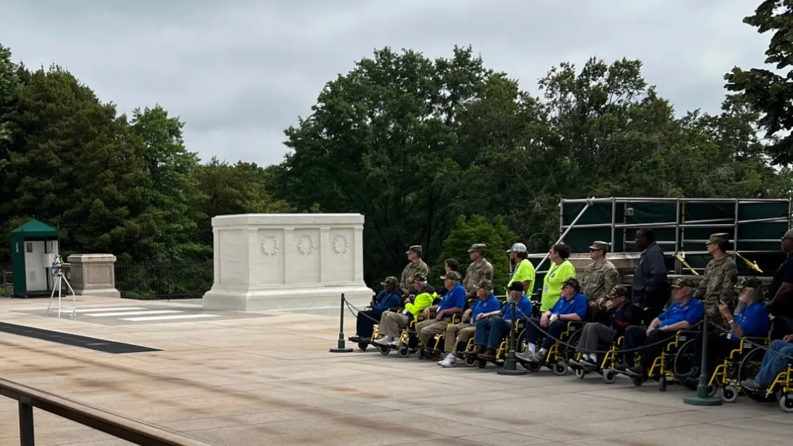 a group of veterans sitting at a memorial