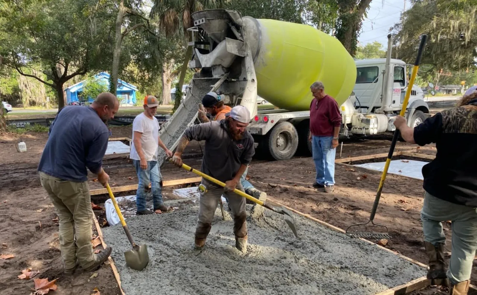 a group of people working on a concrete slab