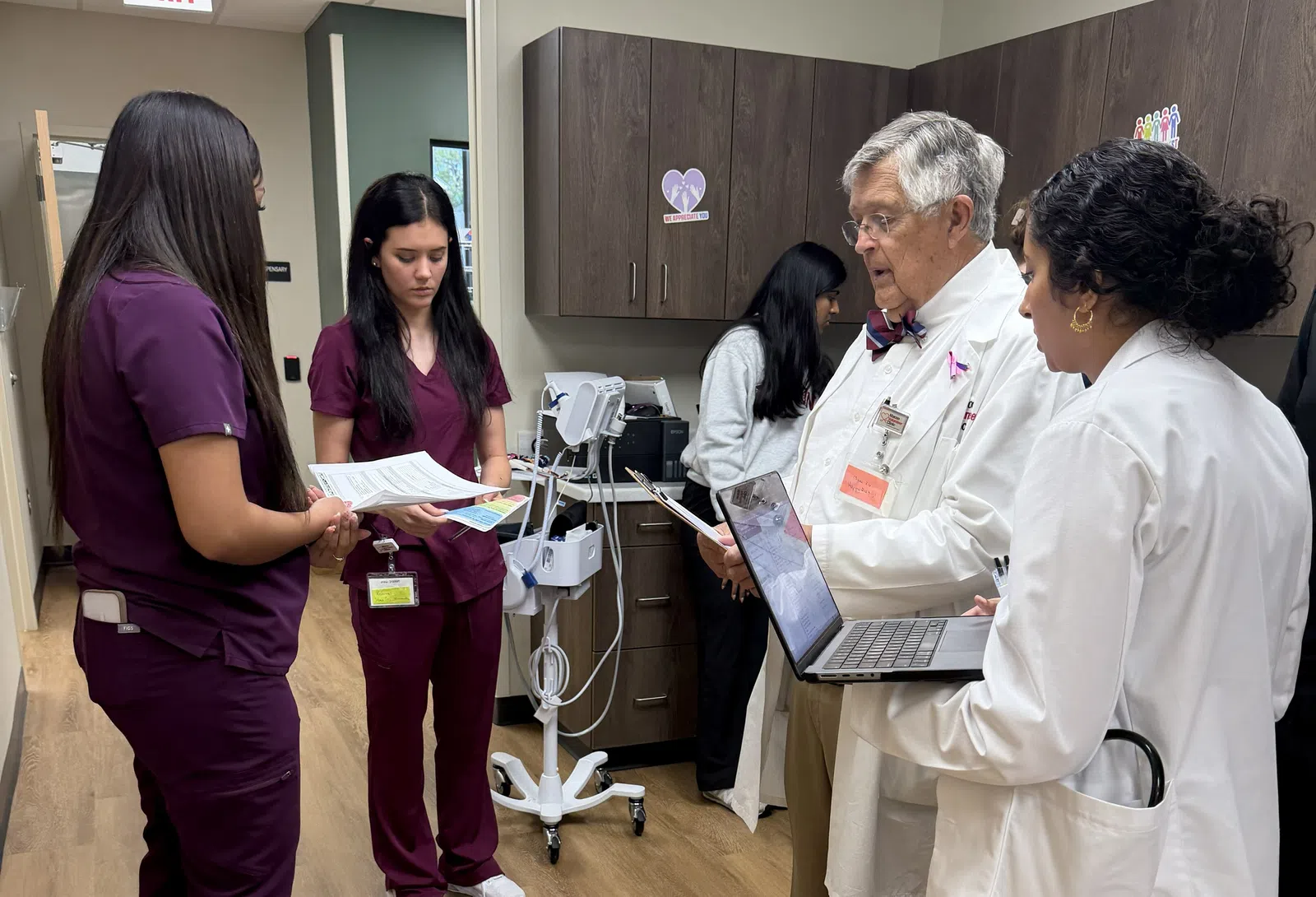 Healthcare professionals in a clinic discussing patient information with overlaid text not present