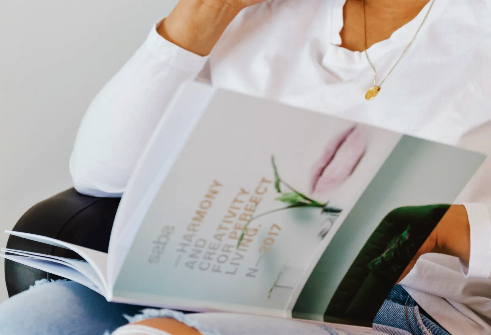 A seated person holding open a large book