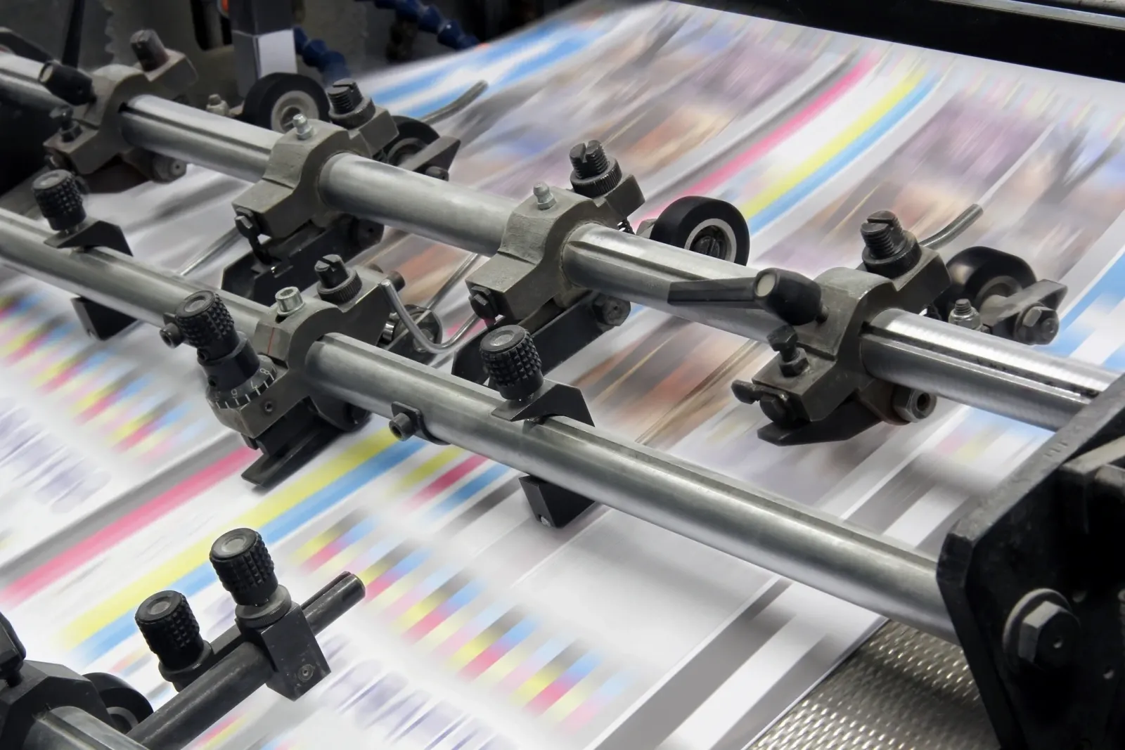 A large sheet of paper being printed on an offset printing press