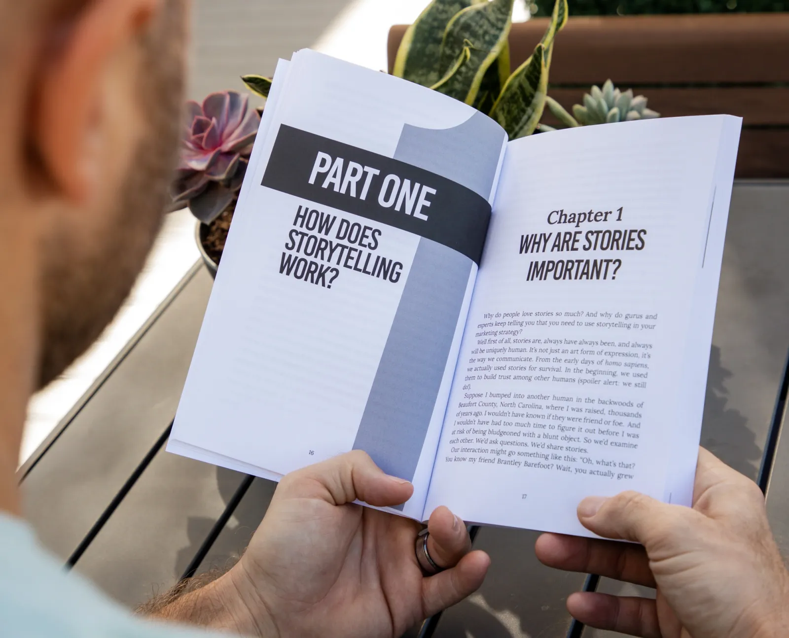 A man reading a book printed in black and grayscale ink