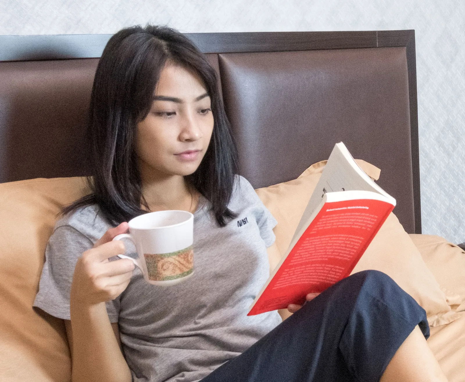 A young woman reading a printed book