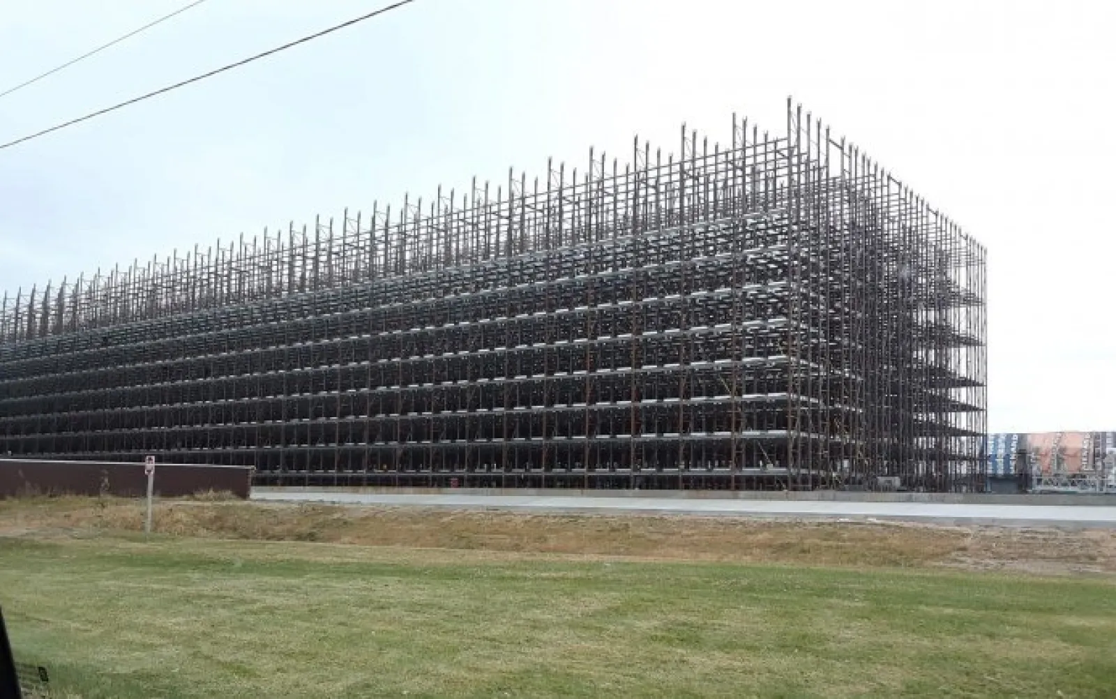 Large industrial metal rack storage structure outdoors with multiple levels and open framework