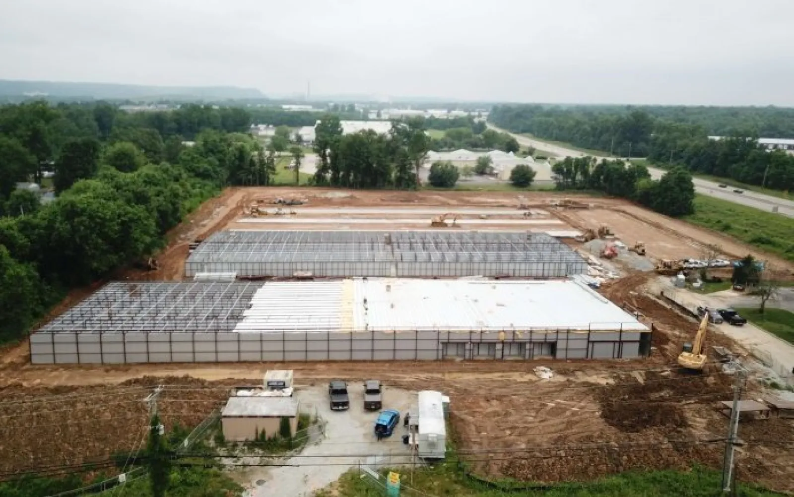 Aerial view of a large industrial building under construction with steel framework and foundation laid out.
