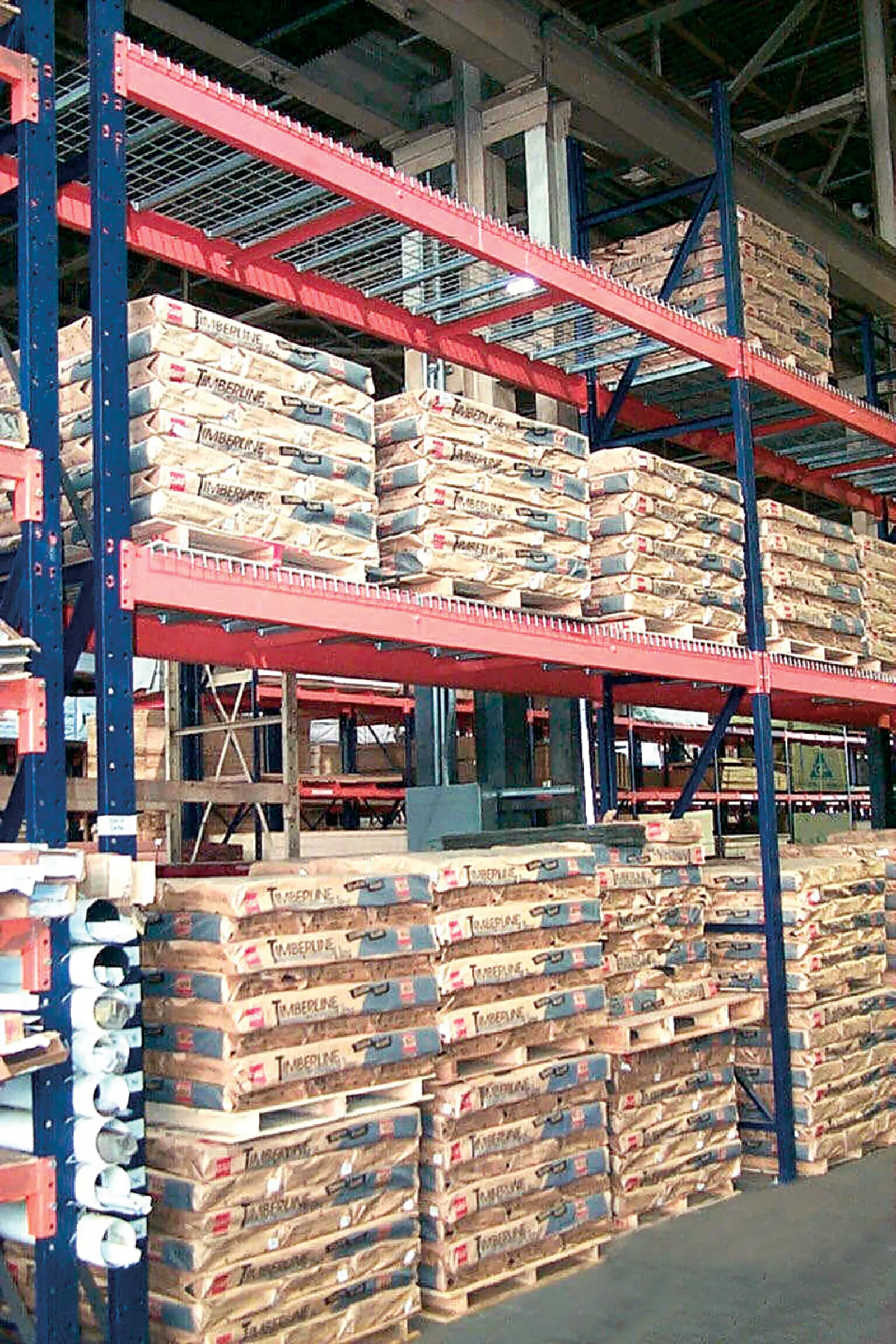 Warehouse shelves stocked with palletized bags of Timberline cement ready for distribution and storage.