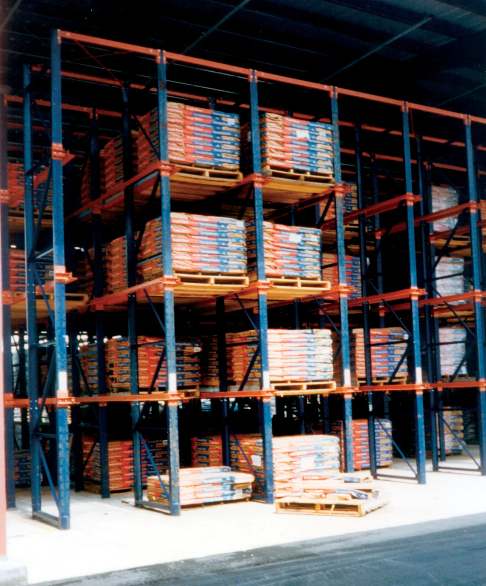 Warehouse racks filled with stacked pallets of packaged goods in an industrial storage facility.