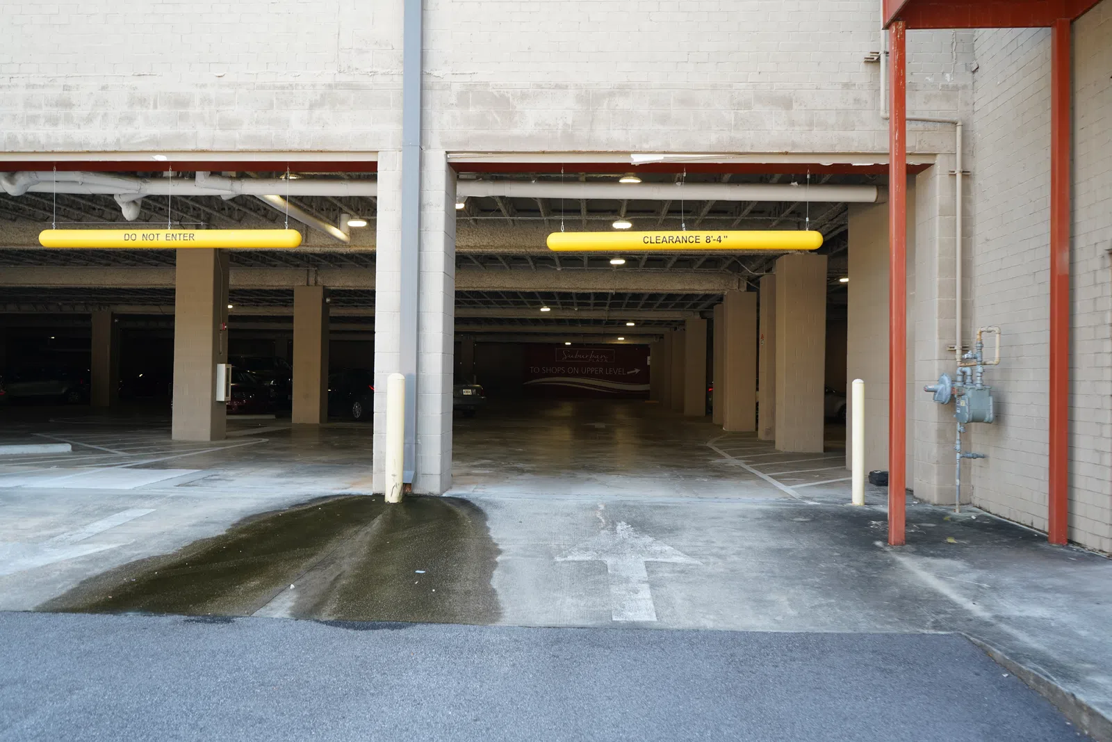 Two adjacent parking garage entrances with clearance signs, one marked Do Not Enter and the other 8-4 clearance.