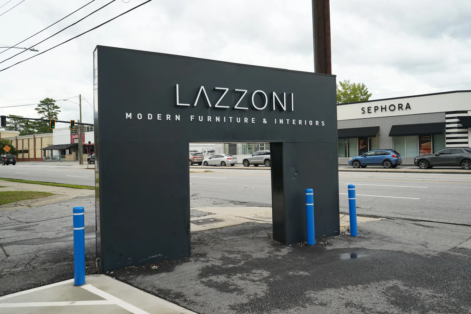 Black Lazzoni modern furniture and interiors sign with a Sephora store and street in the background
