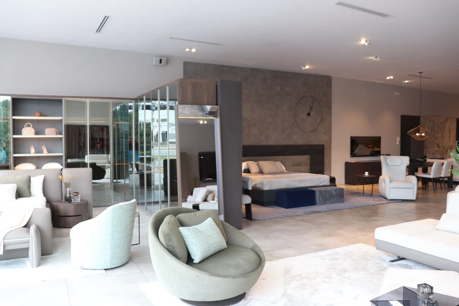 Modern open-concept living space with stylish seating, bed area, and minimalist decor in neutral tones.