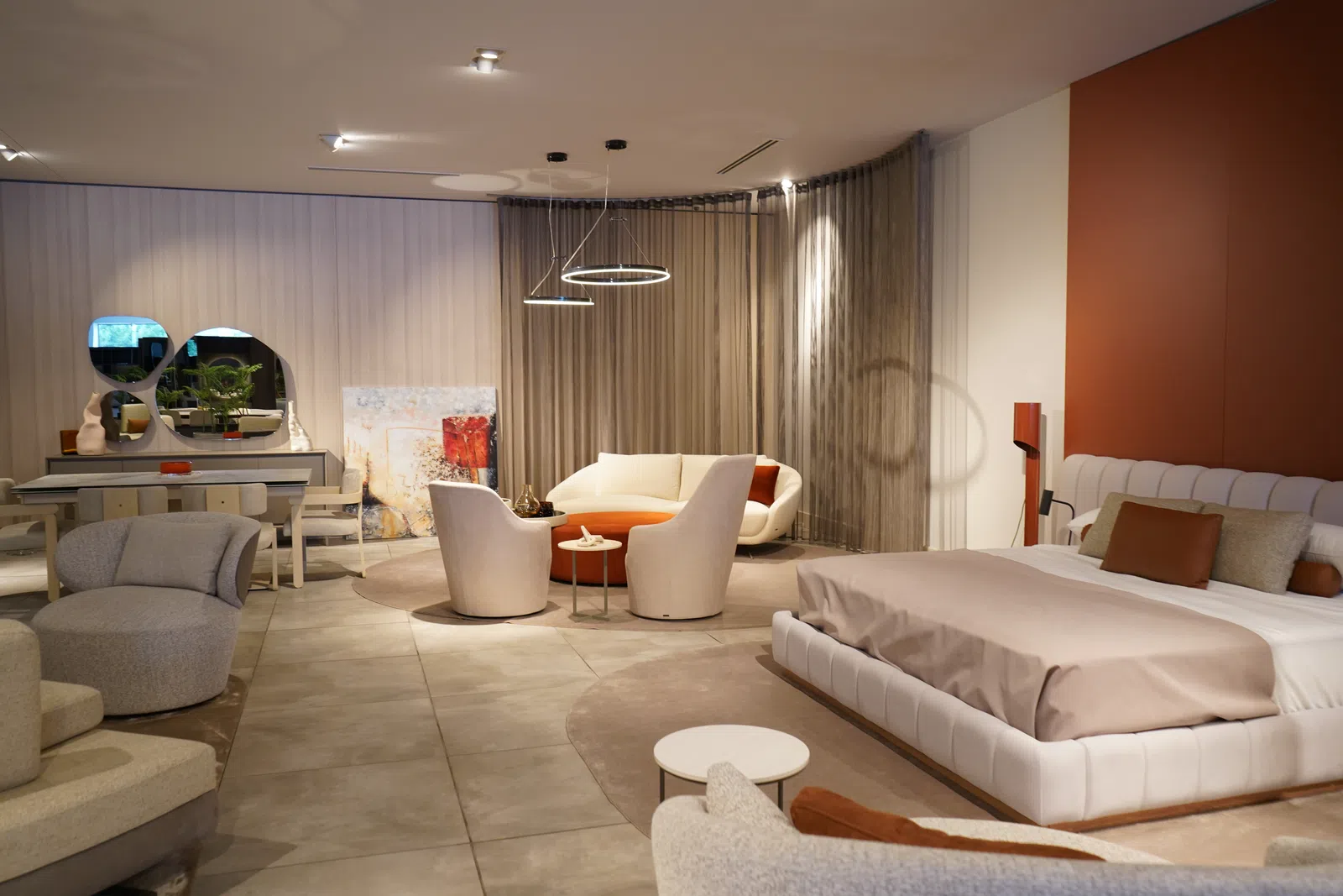 Modern living room and bedroom combination with neutral tones, circular seating area, and minimalist decor.