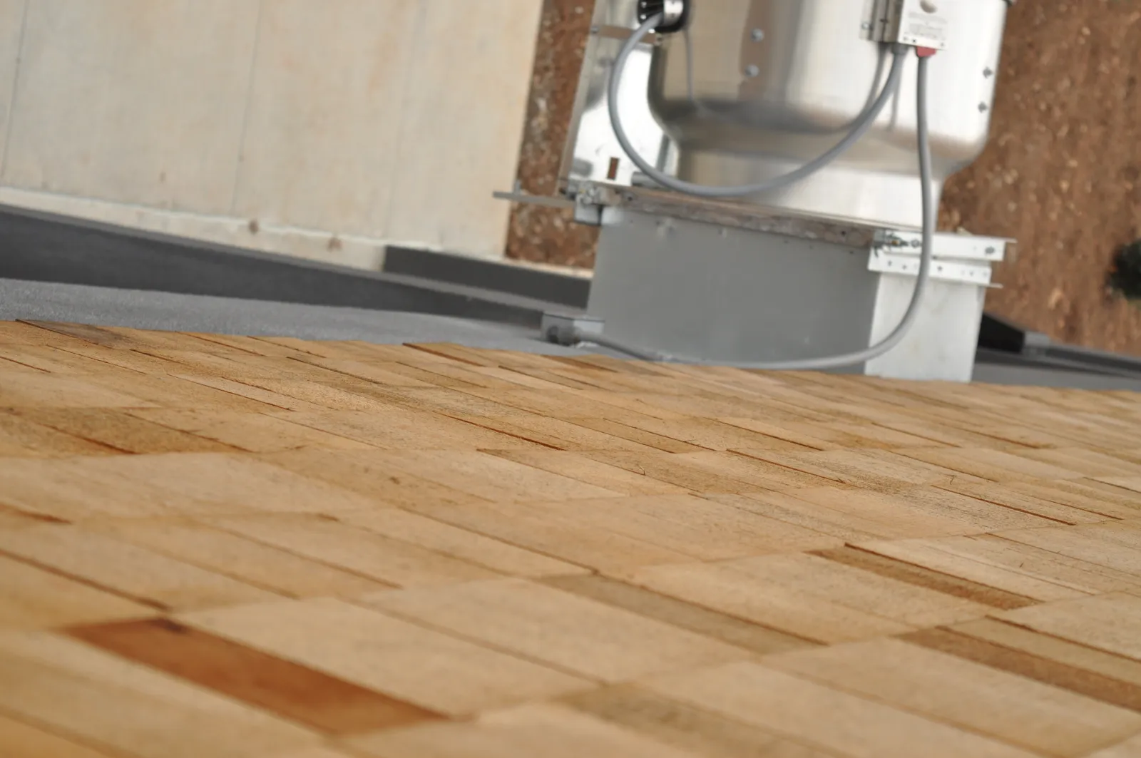 Close-up of a wooden shingle roof with part of a rooftop air conditioning unit in the background.