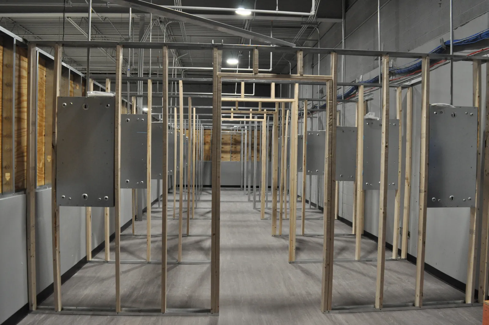 Indoor gun shooting range with multiple target stations and hanging metal target frames inside a large industrial space.