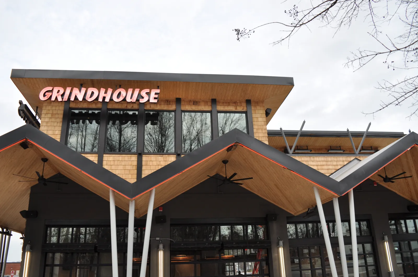 Modern Grindhouse cafe exterior with distinctive zigzag wooden roof and large windows on overcast day