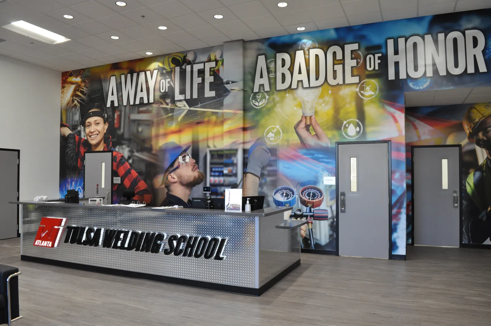 Reception area of Tulsa Welding School with a motto wall displaying A Way of Life A Badge of Honor.