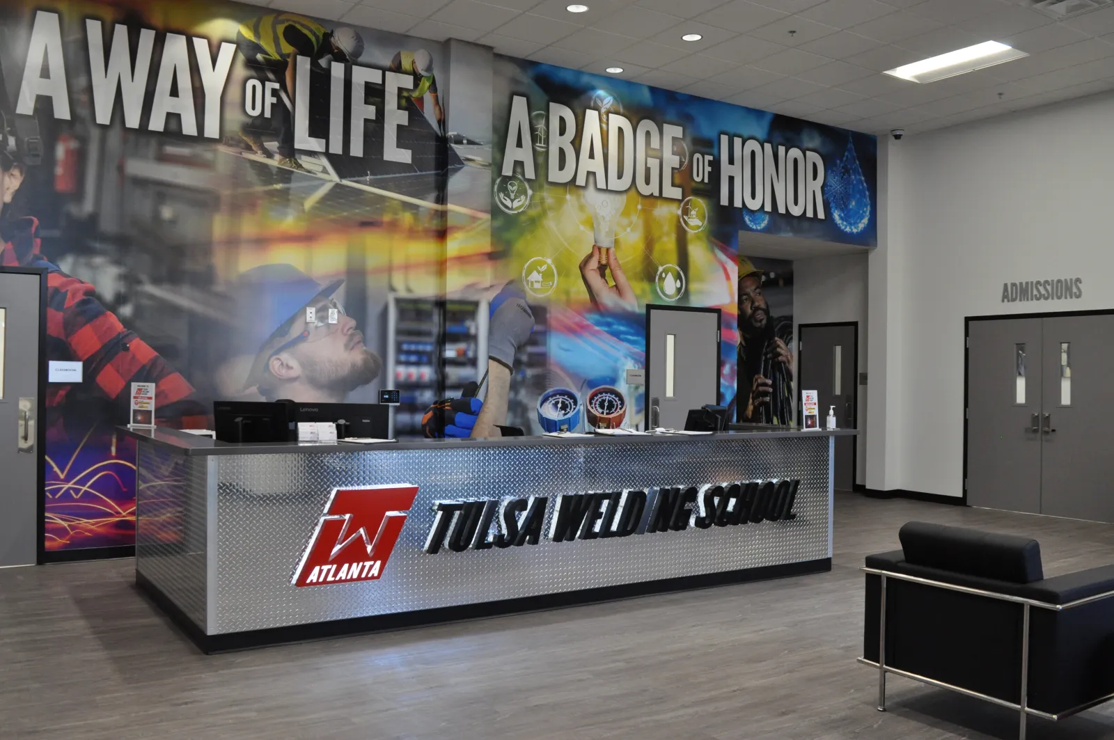 Reception area of Tulsa Welding School with a large mural saying A Way of Life, A Badge of Honor