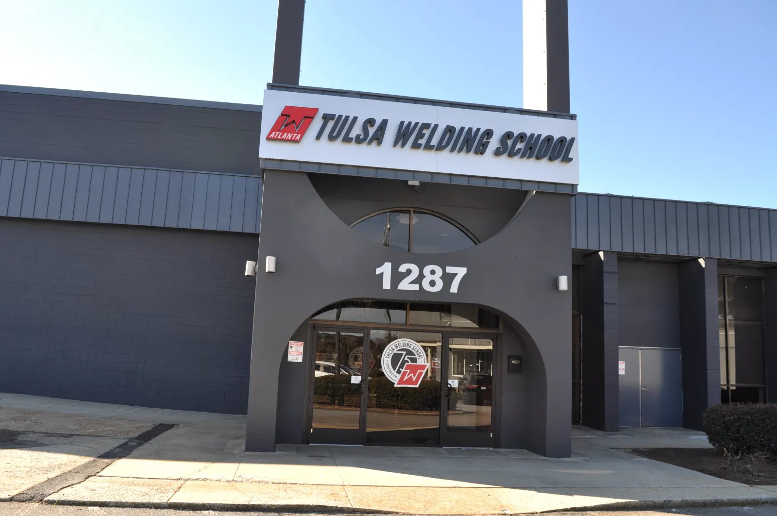 Front exterior of Tulsa Welding School building with address 1287 and large signage on clear day