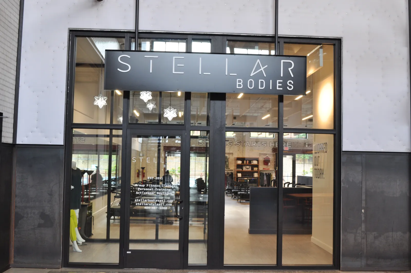 Front glass entrance of Stellar Bodies fitness studio with visible interior workout equipment and signage